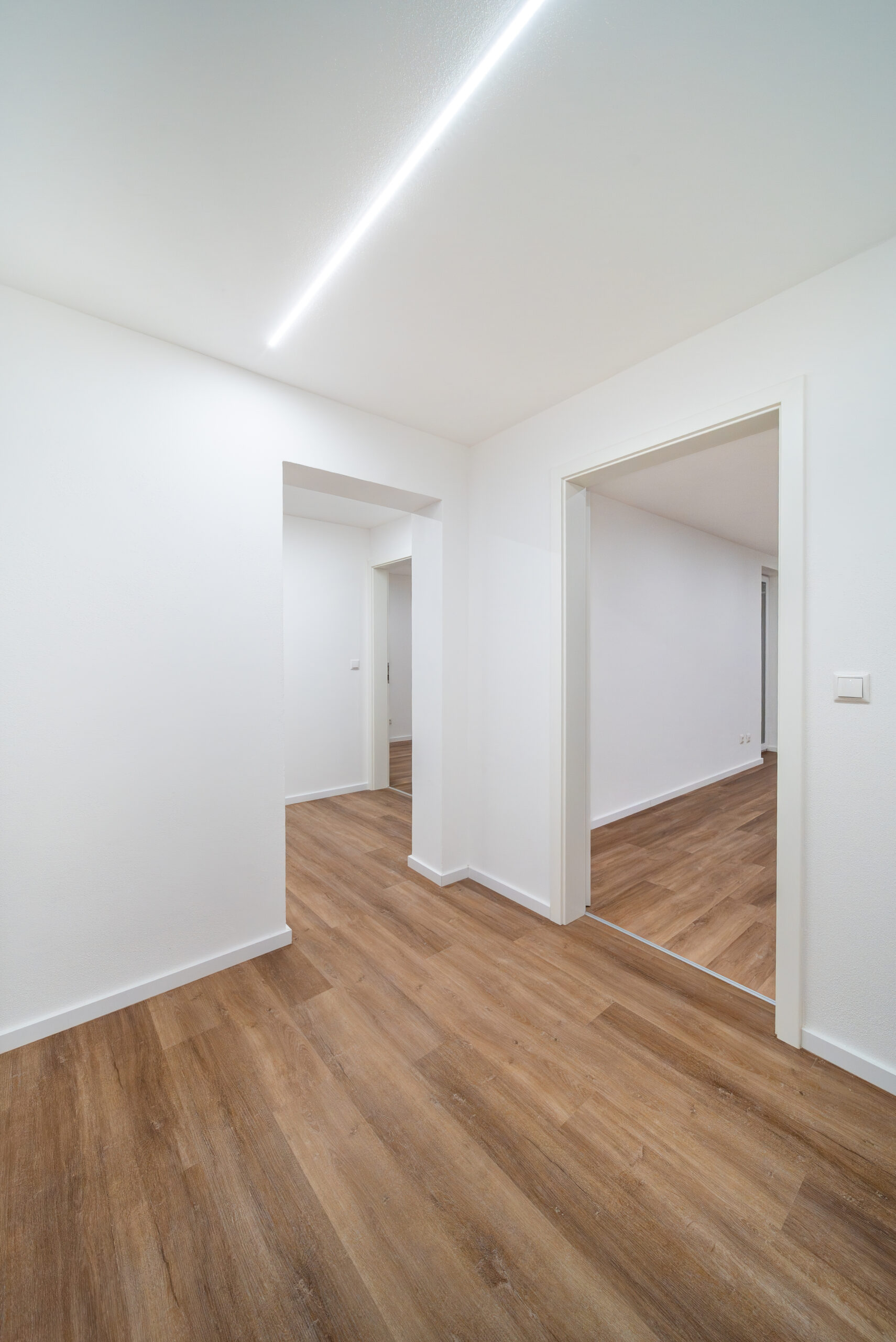 Moderne Immobilie als Kapitalanlage nach Sanierung - Beleuchteter Flur eine Wohnung mit weißen Türen