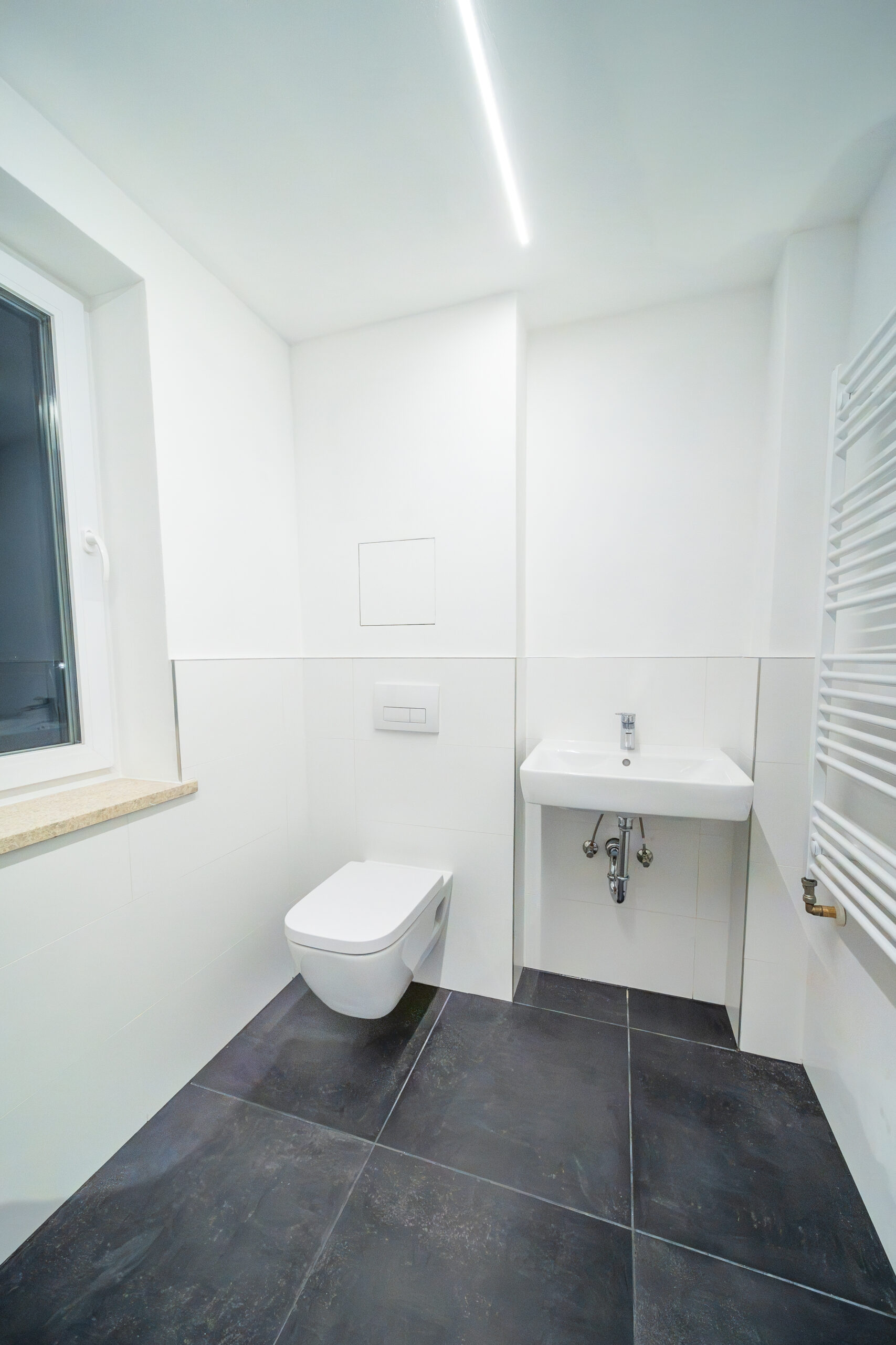 Modernes Bad nach Sanierung mit Heizung, Waschbecken & Toilette